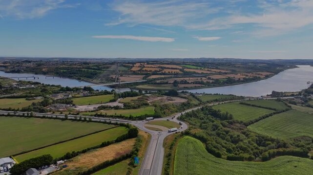 Ireland Amazing aerials drone orbit exit roundabout M9, with Thomas Francis Meagher Bridge and road system with traffic