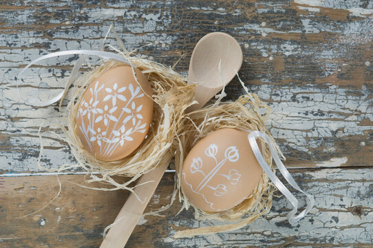 Painted easter eggs in nest with wooden spoon, close up