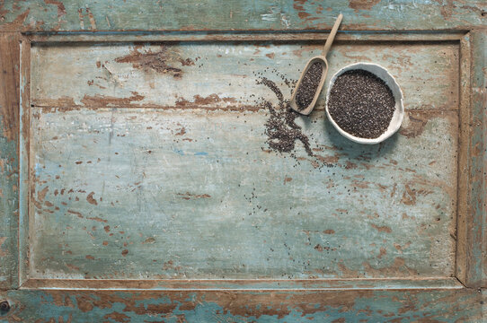 Chia seeds in bowl, shovel on wood