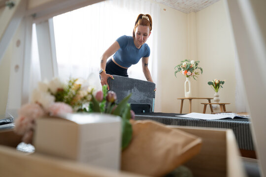 Woman assembles new furniture in her bright home