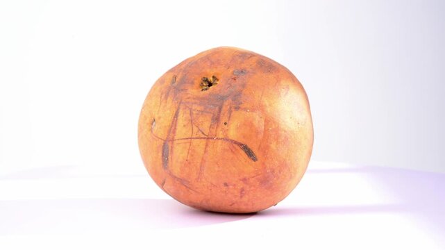 Ripe round pear fruit with marked blemished skin rotating