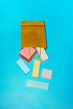 Colorful blank product boxes spilling from a brown shopping bag
