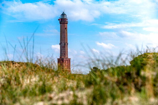 Dune grass surrounds the octagonal brick lighthouse in Norderney
