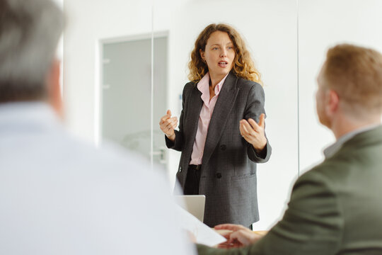 Businesswoman gives a presentation to male colleagues in the office