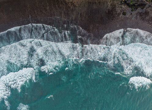 Aerial view of waves crashing against the rocky coastline of Gunungkidul Regency, Special Region of Yogyakarta, Indonesia.