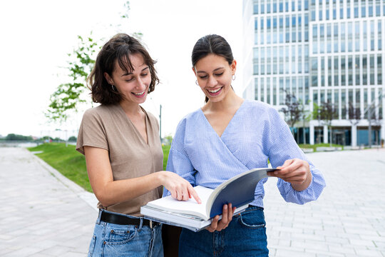 Friends discuss a strategy book outdoors in Hamburg