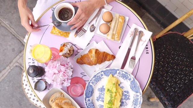 Overhead breakfast table with croissant eggs coffee and juice in Paris