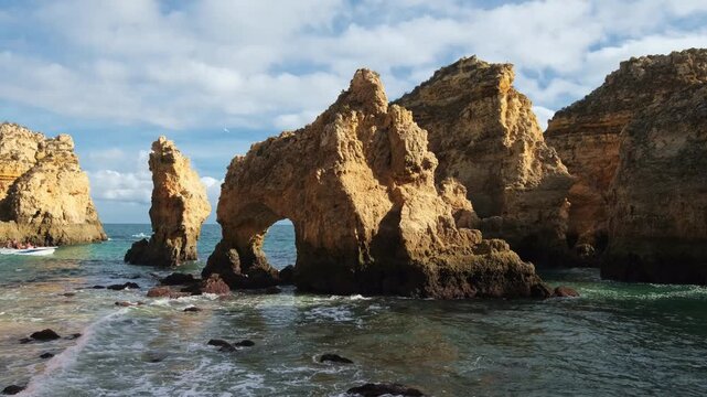 Sunlit limestone cliffs surround the ocean cove at Ponta da Piedade in Lagos, Algarve, Portugal, with sea stacks
