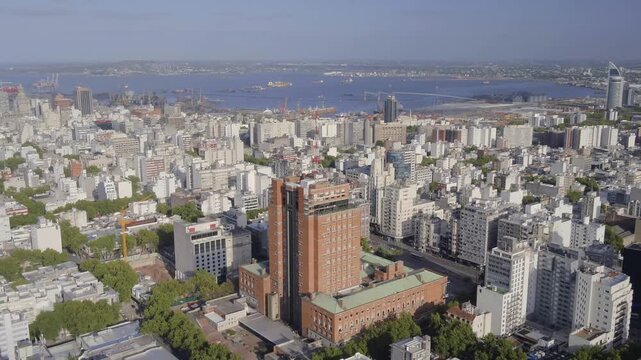 Aerial view of the Intendencia de Montevideo building surrounded by the dense urban skyline and green trees in Montevideo, Departamento de Monte, Uruguay.