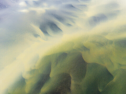 Pale glacial meltwater flows into the sea at �lfus� river estuary