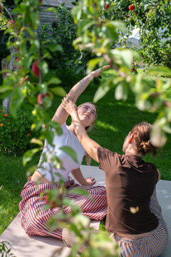 Therapist guides woman during somatic therapy in a sunny garden