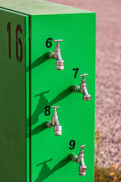 Green mobile water distributor with numbered taps outdoors in Germany