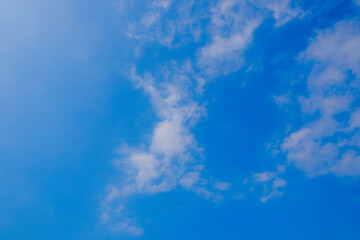 Fototapeta premium Scenic view of sunny blue sky filled with scattered white clouds on a clear day.