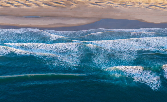Aerial view of waves crashing onto the sandy beach at Bandon, Oregon, United States.