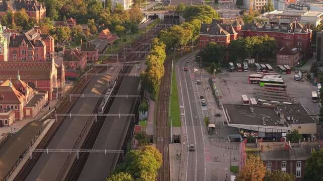 Aerial view of the railway tracks and station area with surrounding urban infrastructure and buses in Gdansk, Pomeranian Voivodeshi, Poland.