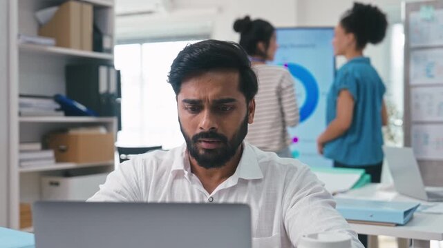 Indian male business working on a laptop at office