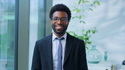 Fototapeta premium Portrait optimistic African American business man looking at camera smiling joyful happy entrepreneur in office ethnic businessman male guy specialist executive smile positive at corporate company