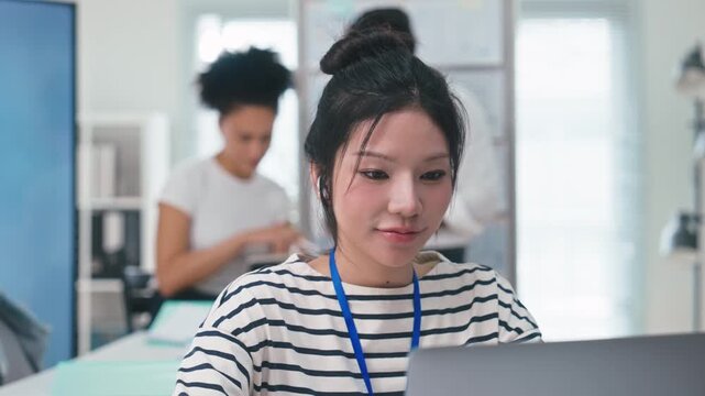 Asian businesswoman listening to music while working in modern office