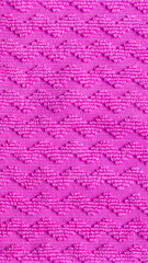 Obraz premium Pink fabric texture with chevron pattern, raised zig zag embroidery details on woven textile background