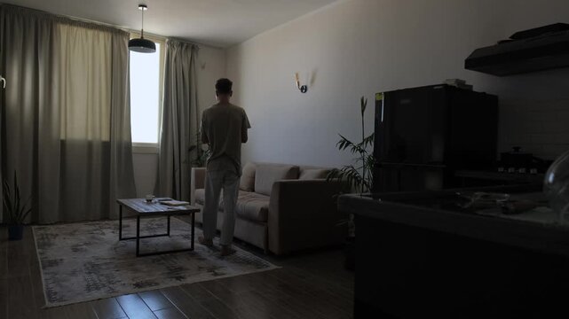 Everyday problem solving and decision making at home, thoughtful man walks around apartment counting options on fingers while considering different choices in a candid lifestyle scene