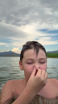 Boy Holding His Nose and Going Underwater in Slow Motion