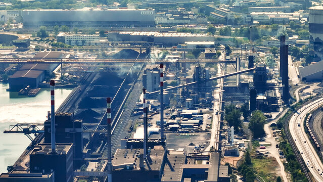 Aerial view of a large steel manufacturing and metallurgical industrial complex with towering chimneys, coal storage piles, and factory infrastructure in Linz, Upper Austria, Austria.