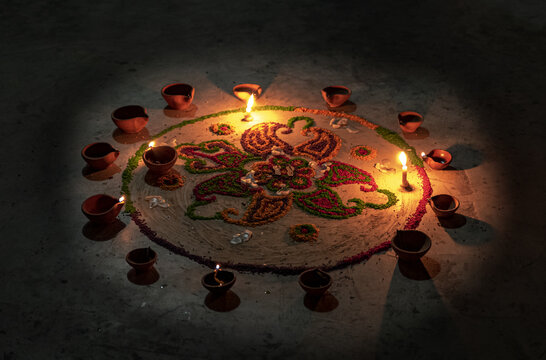View of a colorful rangoli pattern decorated with glowing clay diyas during the Diwali festival in Rahim Yar Khan, Punjab, Pakistan.