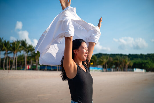 Mindful woman connecting with nature and feeling the breeze during a peaceful morning on the beach
