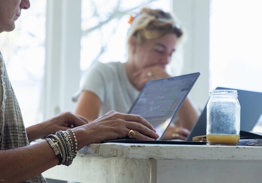 young woman working on laptop in light filled room