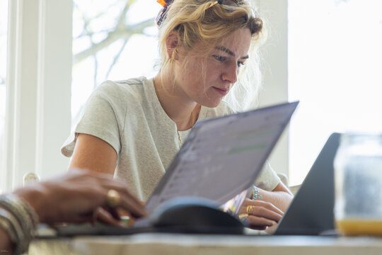 young woman working on laptop in light filled room