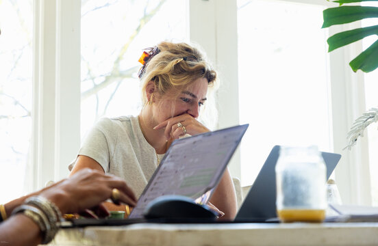 young woman working on laptop in light filled room