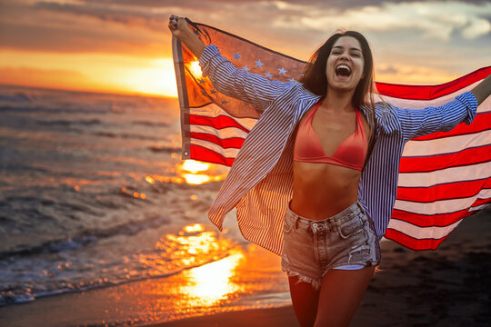 Happy woman running on beach while celebrating independence day and enjoying freedom in USA