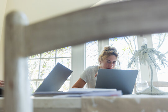 young woman working on laptop in light filled room