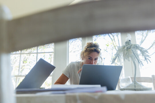 young woman working on laptop in light filled room