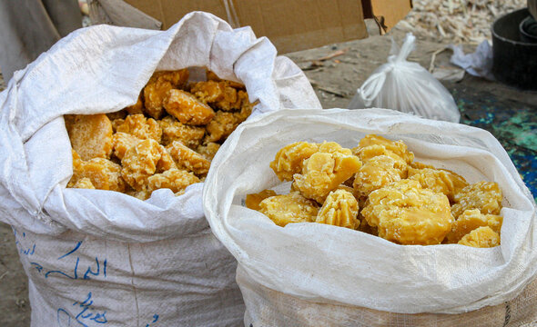 View of traditional jaggery chunks stored in large white sacks at a market in Multan, Punjab, Pakistan.