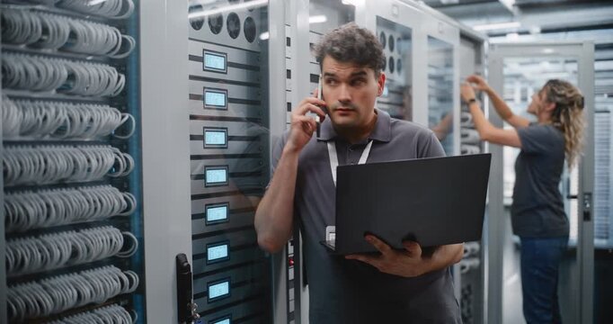 Male Data Center Engineer Reports Server Performance Metrics by Smartphone While Monitoring LED Indicators and Laptop Diagnostics at Rack, Coordinating Technical Operations in Modern IT Facility.