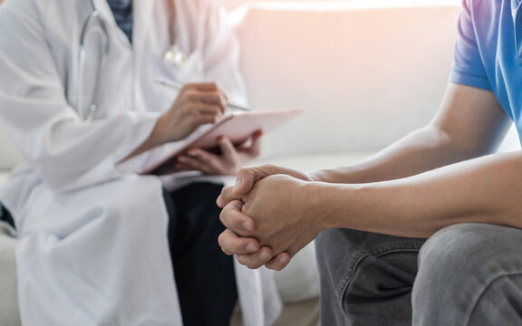 Male patient having consultation with doctor or psychiatrist who working on diagnostic examination on men's health disease or mental illness in medical clinic or hospital mental health service center