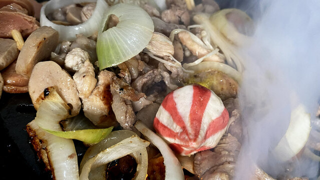 Grilling meat fishballs and onions with rising steam