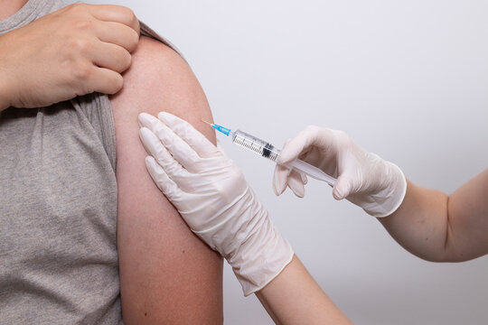 Doctor, nurse vaccinating patient by injecting vaccine into upper arm. Concept of diphtheria vaccination, pertussis vaccination, flu prevention, adult vaccination, public health.