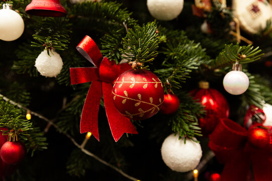 Boule de No&euml;l rouge et dor&eacute;e avec n&oelig;ud brillant sur sapin d&eacute;cor&eacute;