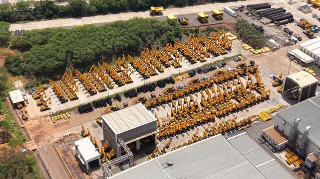 Aerial view of rows of yellow excavators and mining machinery parked at a manufacturing facility in Sriperumbudur, Tamil Nadu, India.