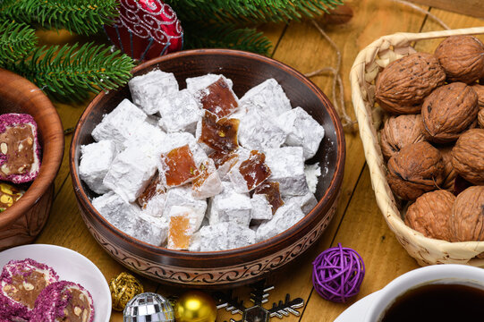 Bowl of Turkish delight powdered with sugar and walnuts on a festive table