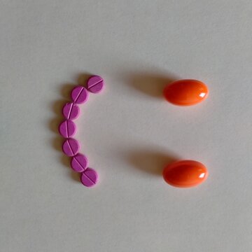 dos grageas grandes naranjas y siete peque&ntilde;as rosas formando carita sonriente