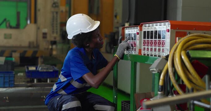 Technician connecting hot runner controller and hydraulic hoses to injection mould in factory