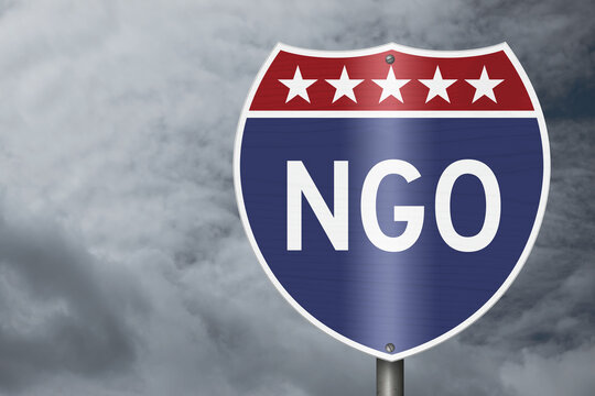 NGO text on an American interstate road sign with stormy sky for non-government organization