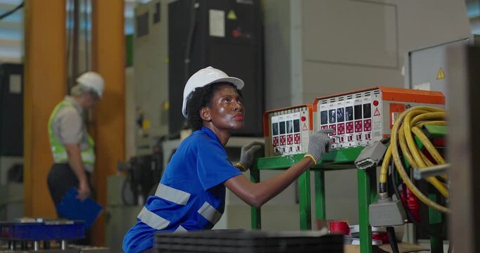 Technician connecting hot runner controller and hydraulic hoses to injection mould in factory