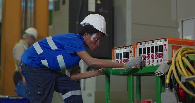 Technician connecting hot runner controller and hydraulic hoses to injection mould in factory