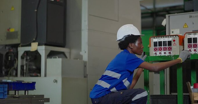 Technician connecting hot runner controller and hydraulic hoses to injection mould in factory