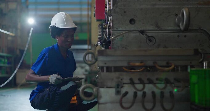 Technician connecting hot runner controller and hydraulic hoses to injection mould in factory
