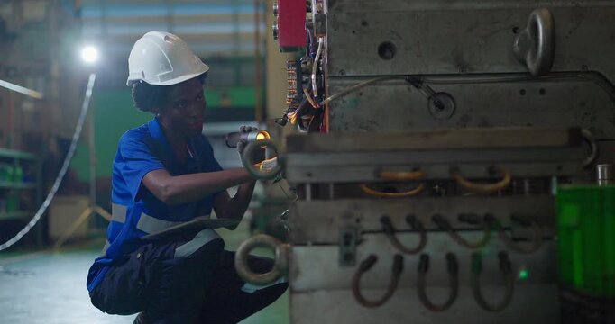 Technician connecting hot runner controller and hydraulic hoses to injection mould in factory